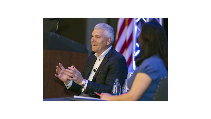 man speaking onstage being interviewed