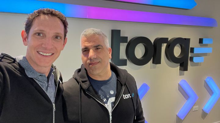 two men in front of company sign at Torq headquarters