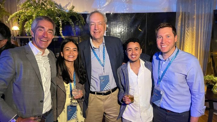 Group photo of five people at a party posed for the camera