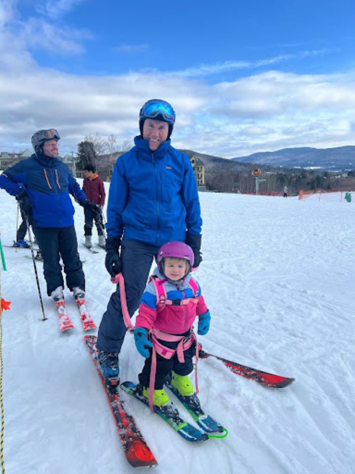 man teaching child to ski