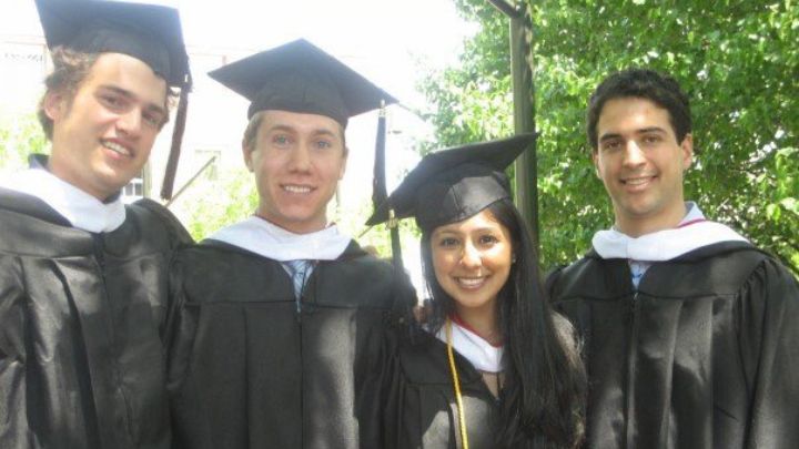 Three young men and one young woman posed in caps and gowns