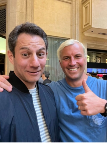 two men posed for selfie with a thumbs up