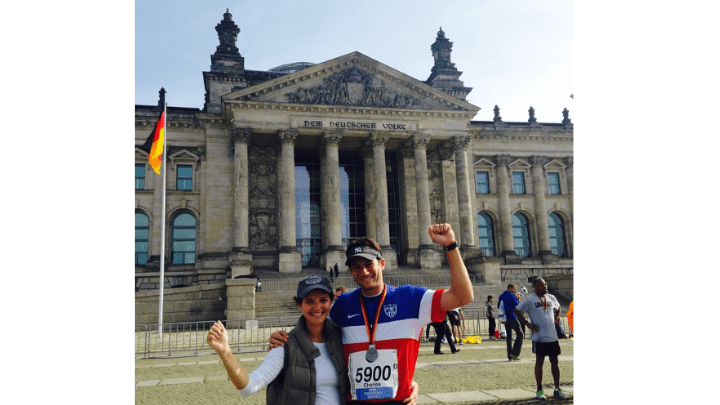 man with marathon medal posed with woman in front of german building