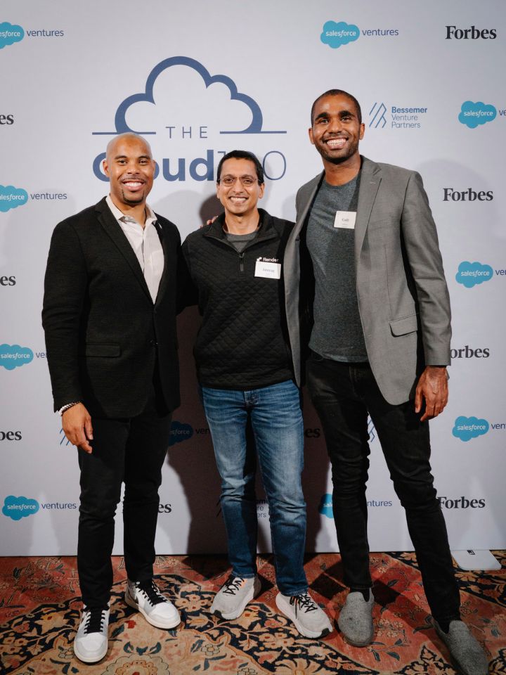 three men posed standing in front of step at repeat