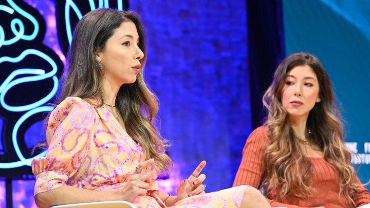 two women sitting on stage speaking