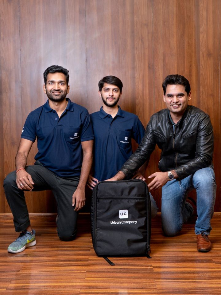 three men posed kneeling with urban company backpack