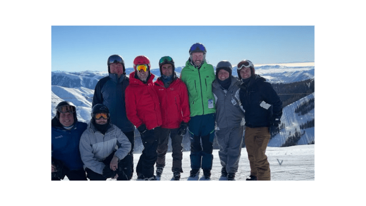 group of skiiers posed at top of mountain