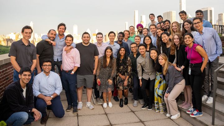 group photo posed on rooftop with skyline behind